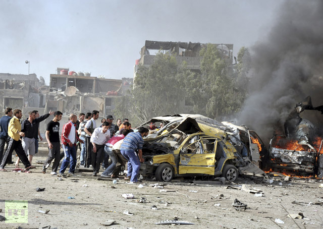 People and security personnel try to remove a car from an explosion site in Damascus May 10, 2012. (Reuters / Sana)